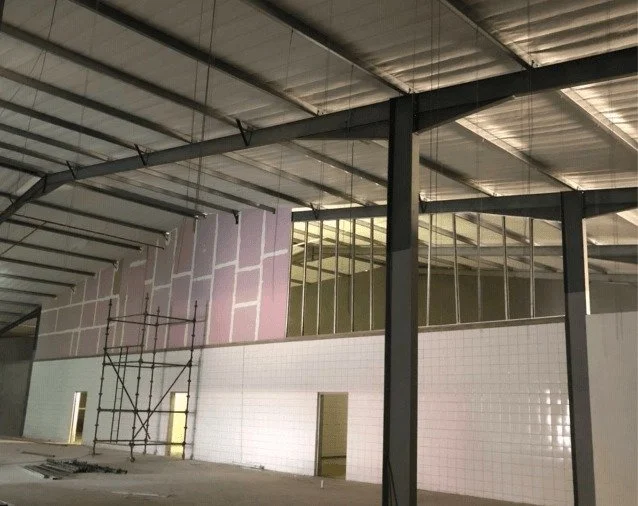 Fire rated drywall busy being installed in a warehouse